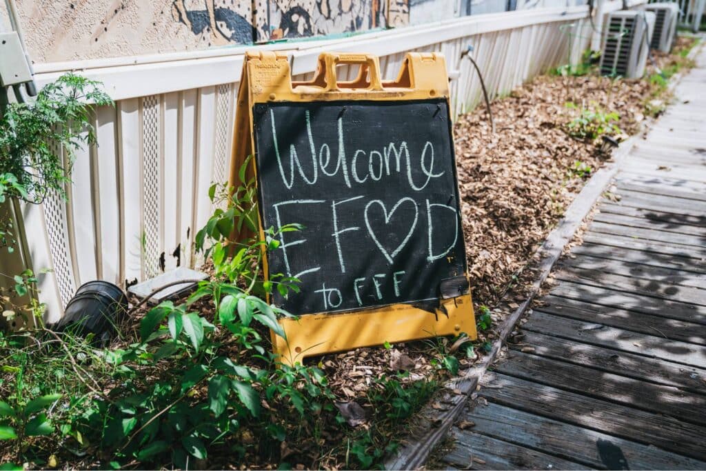 a sign on an organic farm welcoming equitable food oriented development members
